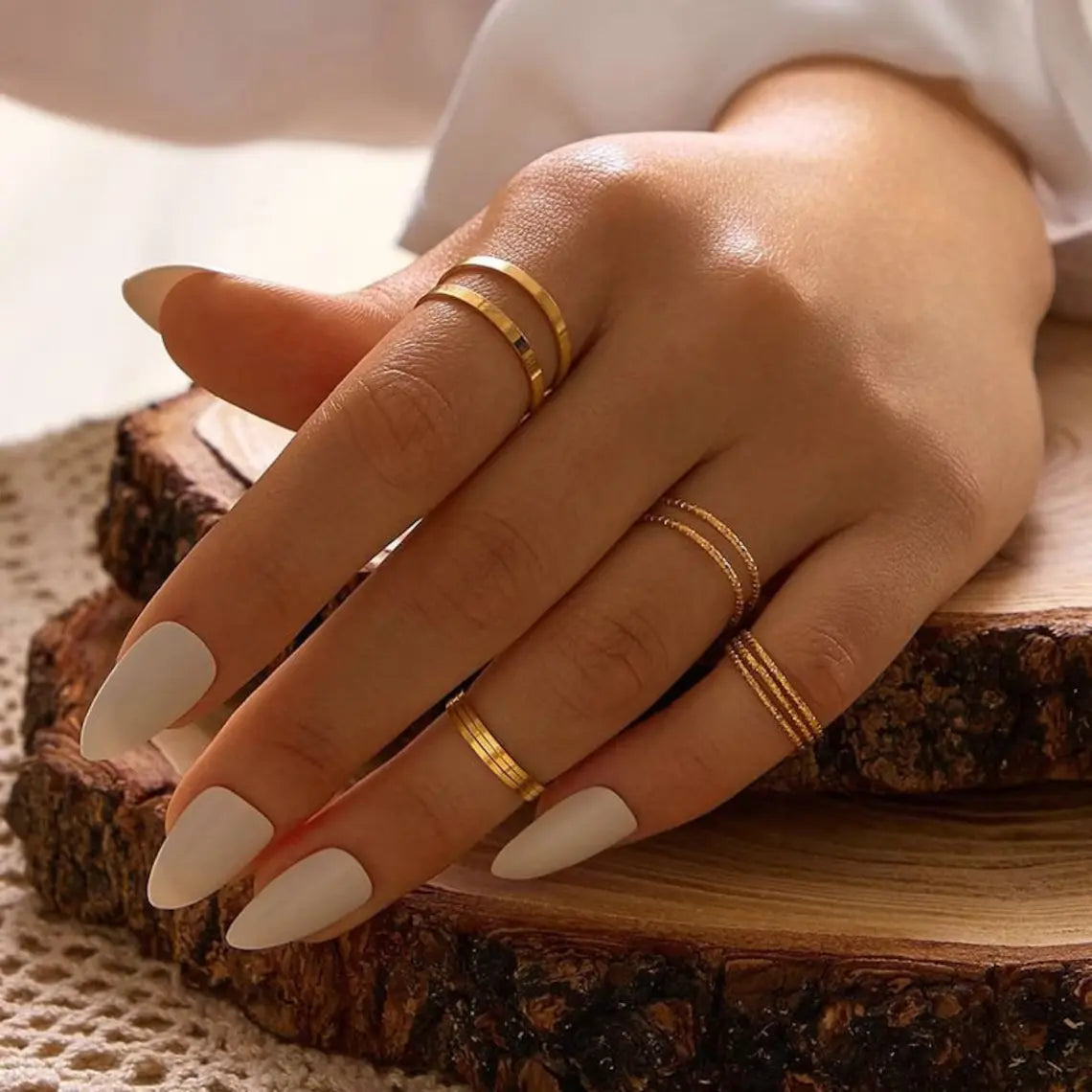 Elegant hand adorned with multiple gold rings, showcasing women's ring jewelry.