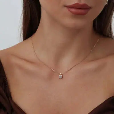 Delicate gold necklace with rectangular pendant, showcasing women's necklace jewelry.