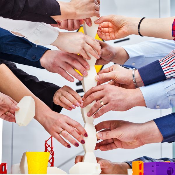 Hands of multiple people working together on a project.