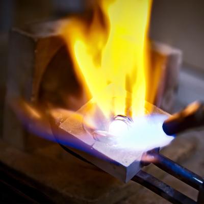 Metal being heated with a flame in a workshop.